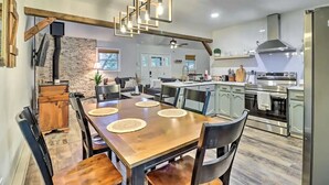 Une cuisine moderne dotée d’un îlot central, d’appareils électroménagers intégrés et d’un coin repas avec une table et des chaises en bois.