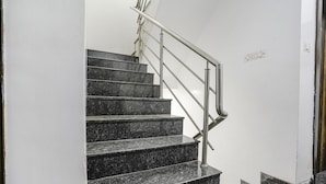 Eine Treppe aus schwarzem Marmor mit einem Metallgeländer, das zu einer Zwischenebene führt.