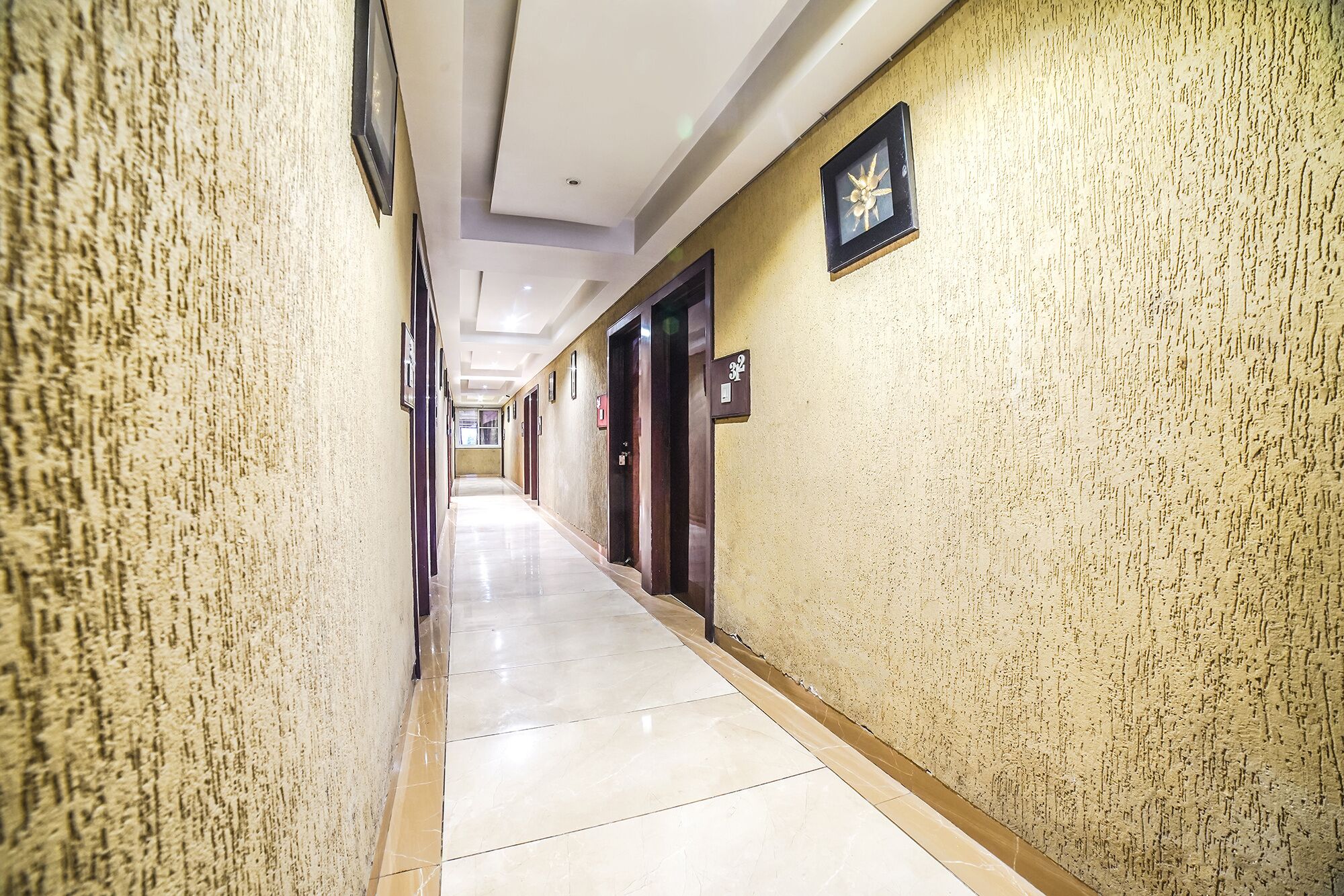 A long, narrow hallway with a tiled floor and textured walls.