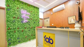 A reception desk with a green wall and a neon sign that reads "Welcome to Fab Hotels." - FabHotel Kavya Inn (Faridabad)