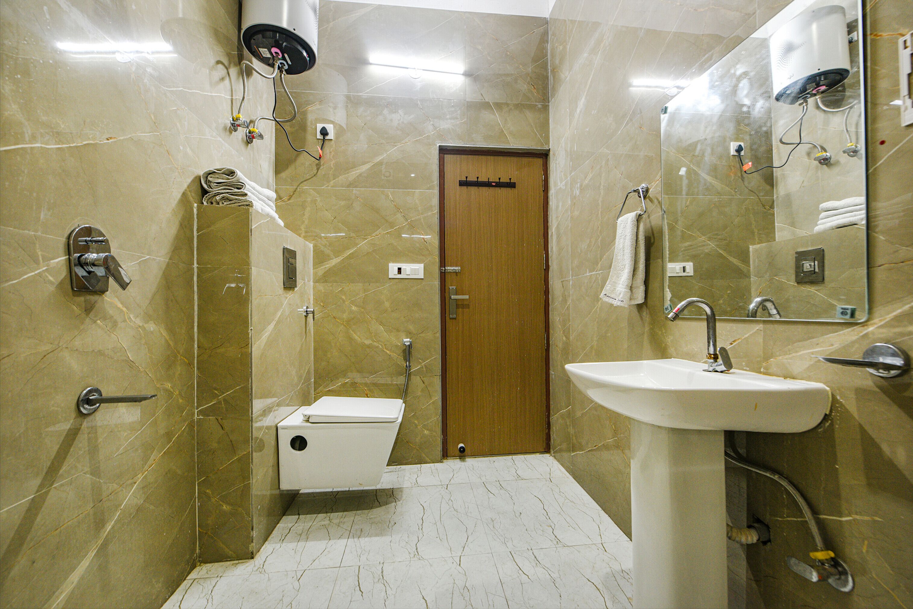 Une salle de bain avec des toilettes, un lavabo et un miroir.