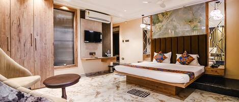 A modern bedroom with a large bed, a TV, and a wooden wardrobe.