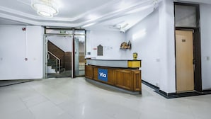 A reception area with a wooden counter, a chandelier, a staircase, and a door marked '108'. - Fabhotel Sunrise Villa (New Delhi)