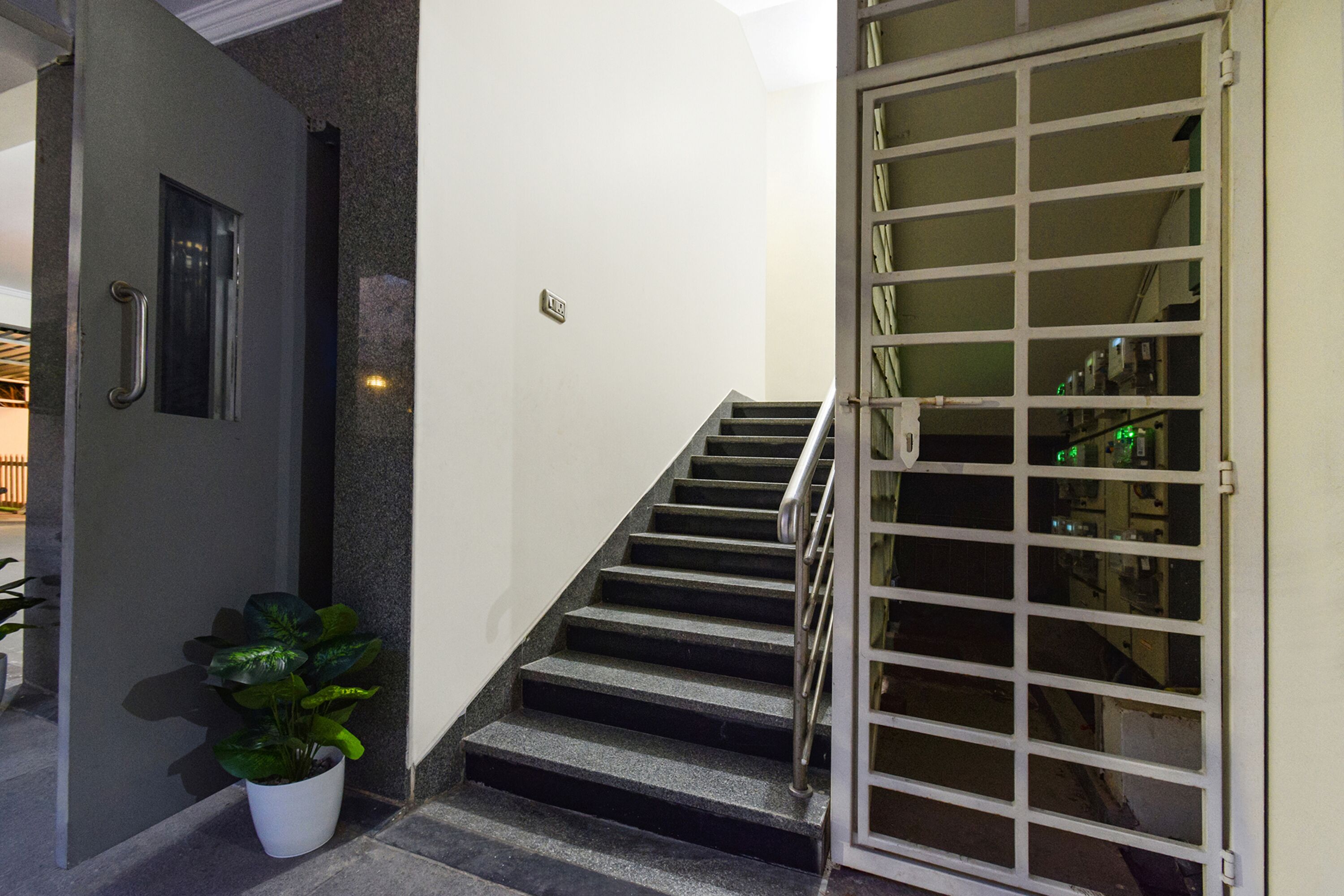 A staircase with a metal railing leading to a door with glass panels.