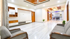 A spacious living room with a wooden ceiling, a dining area, and a kitchen in the background. - Fabhotel De Alphabet Ii (Hyderabad)