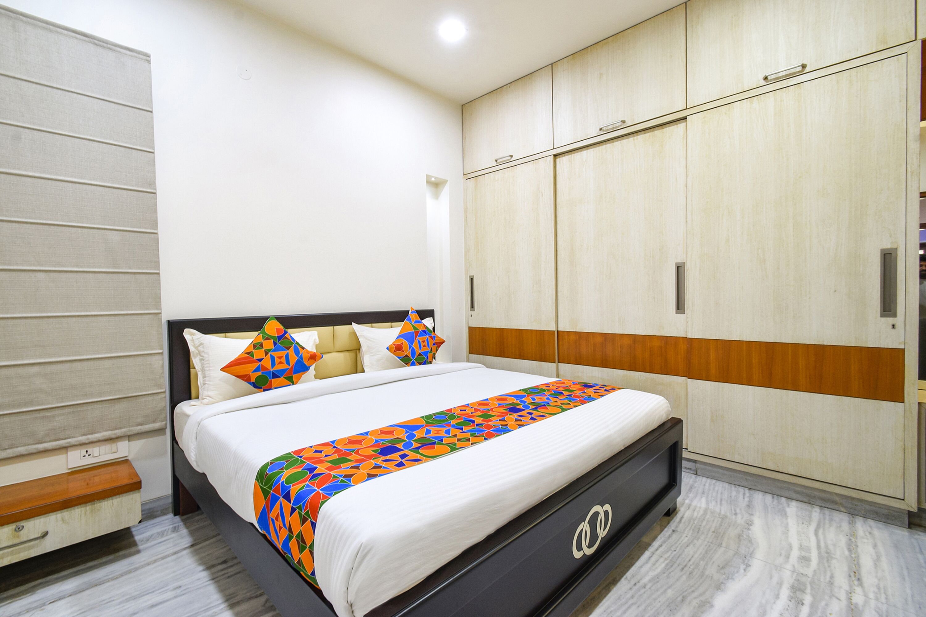 A bedroom with a bed, a wardrobe, and a bedside table.