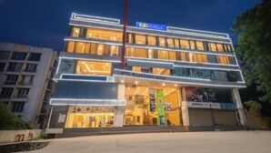 Un hôtel à plusieurs étages, reconnaissable à son grand panneau « fab hotels », à ses larges fenêtres et à son architecture moderne.