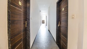 A corridor with two doors marked 101 and 106, leading to a bright hallway. - Fabhotel Seven Seas (Pune)