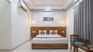 A bedroom with a wooden bed, a desk, and a chair. - Fabhotel New Journey Hospitality (Gurugram)