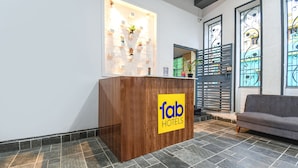 A reception desk with a 'fab hotels' sign, a grey sofa, and a decorative wall with plants. - Fabhotel Welcome Premium (Bhubaneshwar)