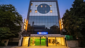 Un hotel moderno con fachada de vidrio, una ventana circular destacada y el letrero de 'fabHOTELS'.
