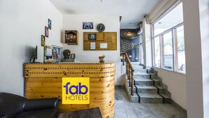 Een houten receptiebalie, een trap en een groot raam met uitzicht.