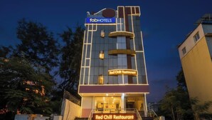 Un bâtiment avec une enseigne indiquant « fabHOTELS » et « Red Chili Restaurant » à l’entrée.