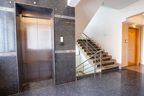 An elevator and a staircase in a modern building. - FabHotel Trubell Electronic City (Anekal)