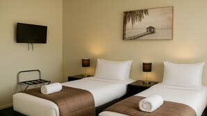 A hotel room with two beds, a TV, and a painting on the wall. - The Post Hotel (Porirua)