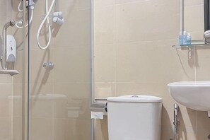A bathroom with a glass shower enclosure, a toilet, and a sink. - Chariton Hotel Skudai Kiri (Johor Bahru)