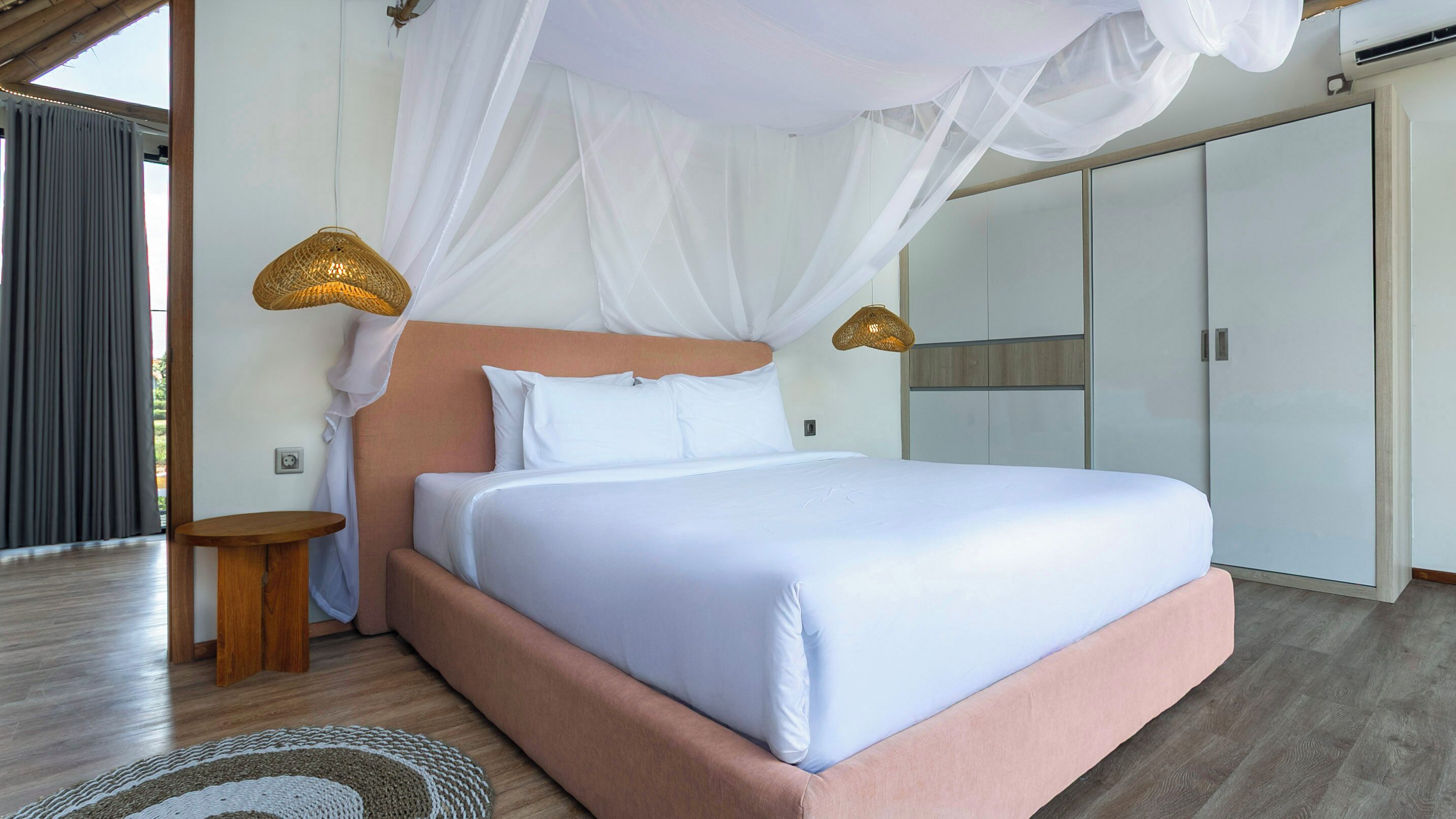 A bedroom with a bed, a nightstand, a small table, and a wardrobe.