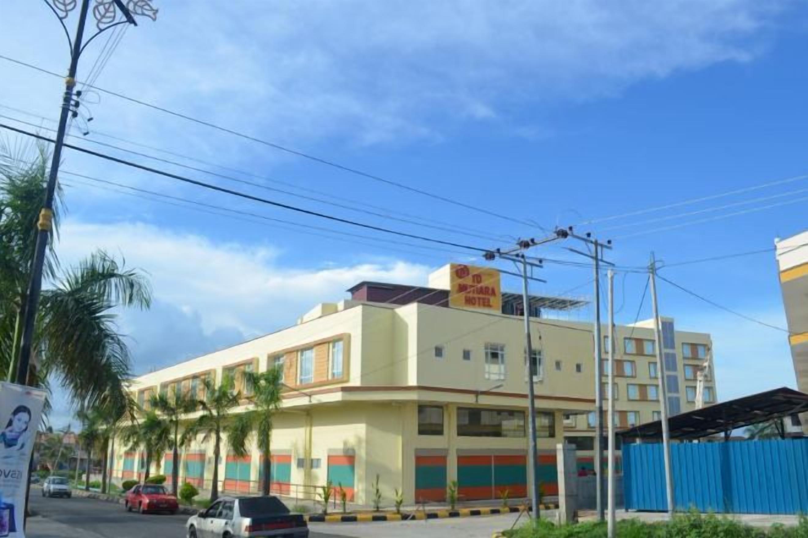 A multi-story building with a flat facade, several windows, and a sign on the roof.