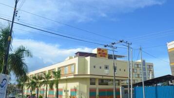 A multi-story building with a flat facade, several windows, and a sign on the roof.