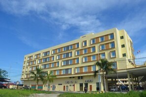 A multi-story hotel with a flat facade, multiple windows, and a covered entrance area. - TD Mutiara Hotel (Semporna)