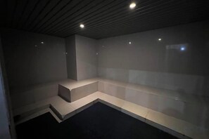 A room with a dark floor, a light-colored bench, and a ceiling with recessed lighting. - Nick's Homestay @ Boulevard Mall @ Imperial Suites Kuching (Kuching)