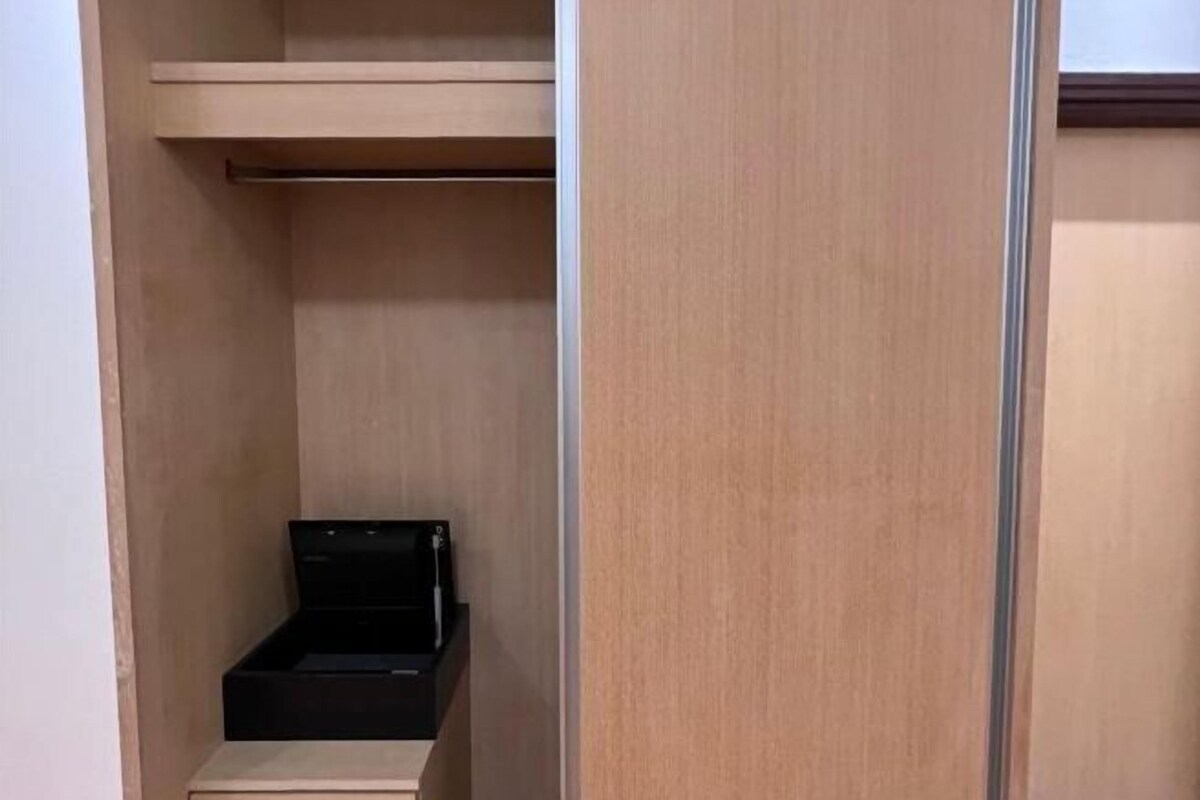 A small, enclosed closet with a single black storage box.