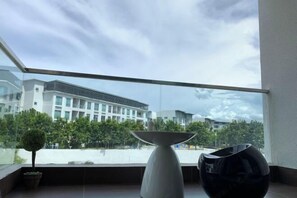 Una habitación moderna con un ventanal grande, una planta en maceta y un jarrón minimalista.