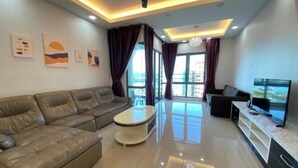A modern living room with a leather sofa, a coffee table, a TV, and artwork on the walls. - Paradise Suite at the Loft, Imago (Kota Kinabalu)