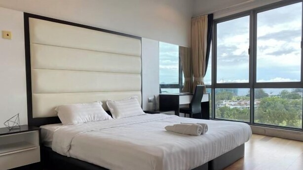 A modern hotel room with a large bed, a desk, and a view of the city. - Paradise Suite at the Loft, Imago (Kota Kinabalu)
