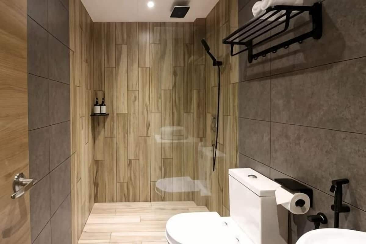 A modern bathroom with a shower, toilet, and sink.