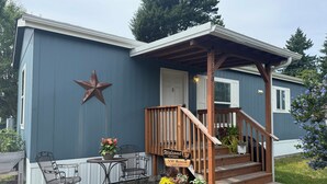 A blue building with a wooden porch, a star decoration, and a sign welcoming visitors to the NW Retreat.