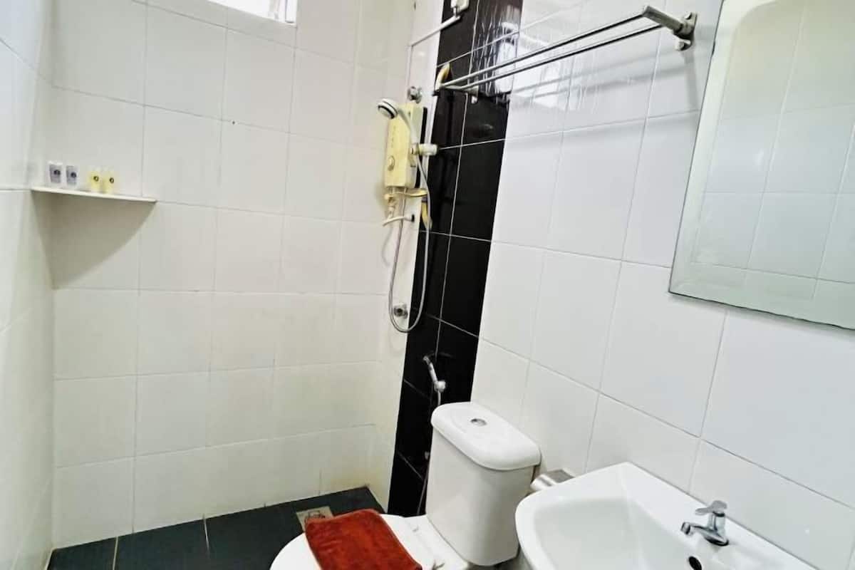 A small bathroom with a toilet, a sink, and a shower.