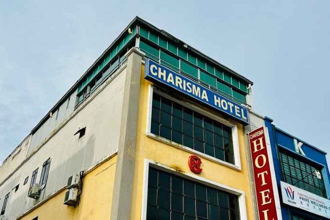Ein Gebäude mit einem Schild, auf dem 'CHARISMA HOTEL' steht, und einem roten Logo.
