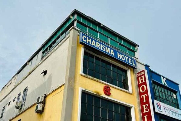 A building with a sign reading 'CHARISMA HOTEL' and a red logo.