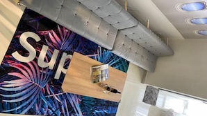A modern living room with a grey sofa, a wooden coffee table, and a vibrant abstract wall mural. - Terminal VIP Lounge @ Near KLIA Sepang (Sepang)