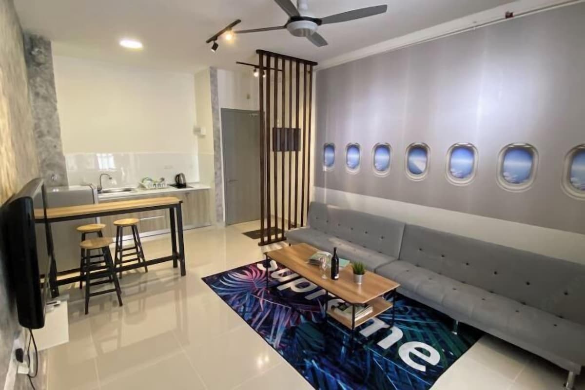 A modern living room with a sofa, a coffee table, and a TV.