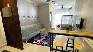 A modern hotel room with a sofa, a small table, two bar stools, a ceiling fan, and a TV mounted on the wall. - Terminal VIP Lounge @ Near KLIA Sepang (Sepang)