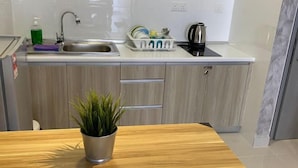 A modern kitchen with a wooden countertop, a sink, and a potted plant. - Terminal VIP Lounge @ Near KLIA Sepang (Sepang)