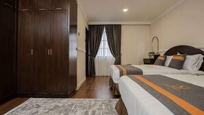 A hotel room with a wardrobe, a bed with a striped bedspread, a nightstand, and a window with curtains. - SpringHill Resort (Brinchang)
