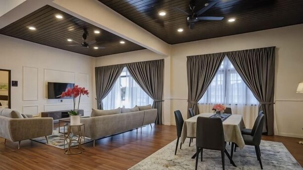 A modern living room with a sofa, dining table, chairs, and a TV. - SpringHill Resort (Brinchang)