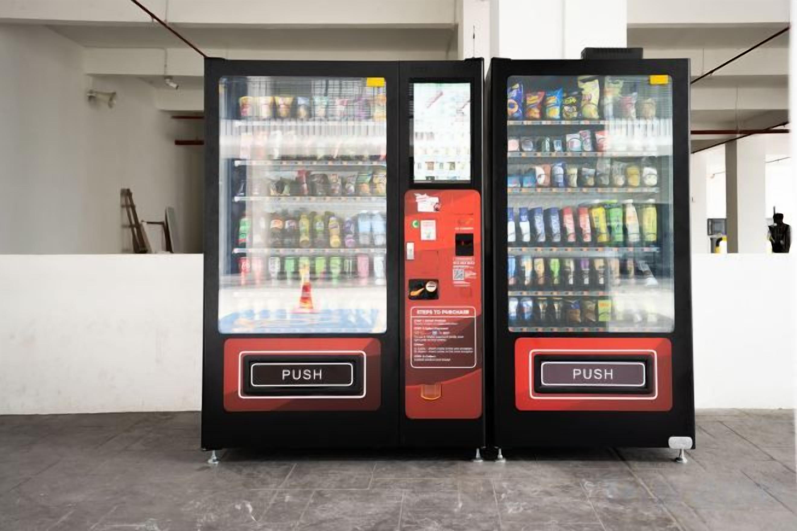 Two vending machines with a push button, one with a red panel and the other with a black panel.