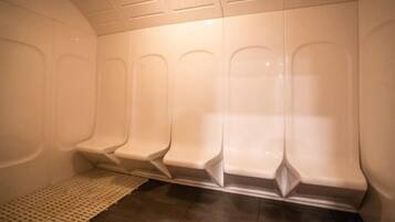 Une rangée de sièges blancs, vides, de type banc, avec un tapis à motifs sur le sol.