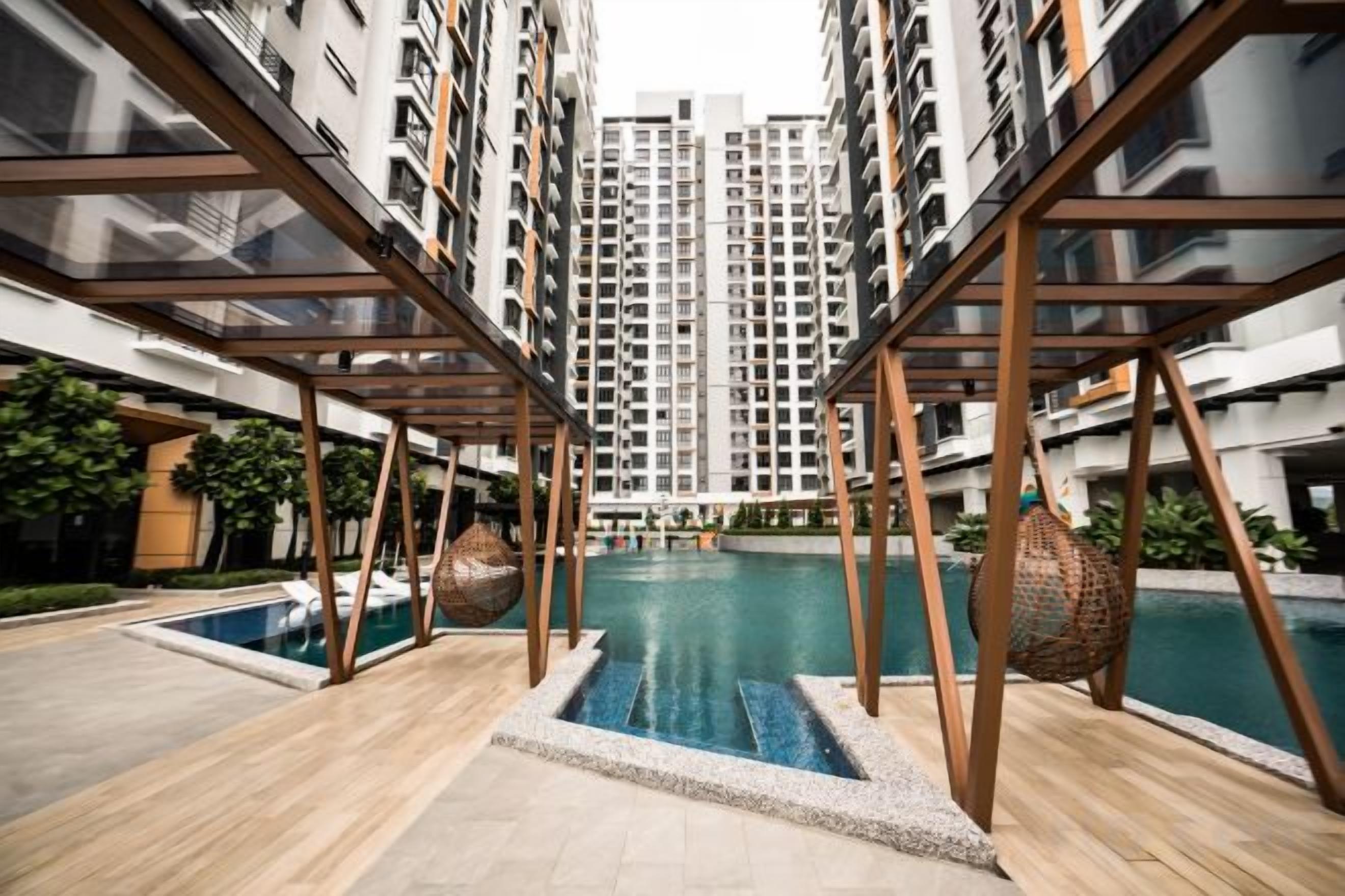 A residential building with a swimming pool, wooden deck, and modern architecture.