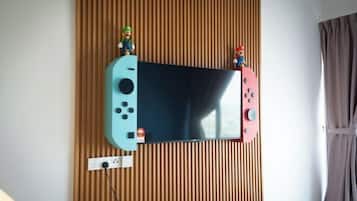 Ein an der Wand befestigter Fernseher mit je einer Mario-Figur an jeder Seite.