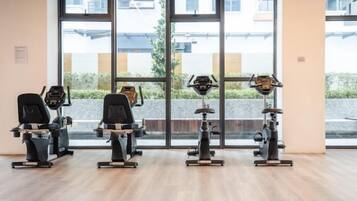 A gym with cardio machines and a large window.