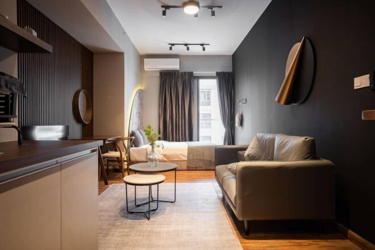 Un salon moderne comprenant un canapé, une table basse et un coin repas avec un comptoir de cuisine.