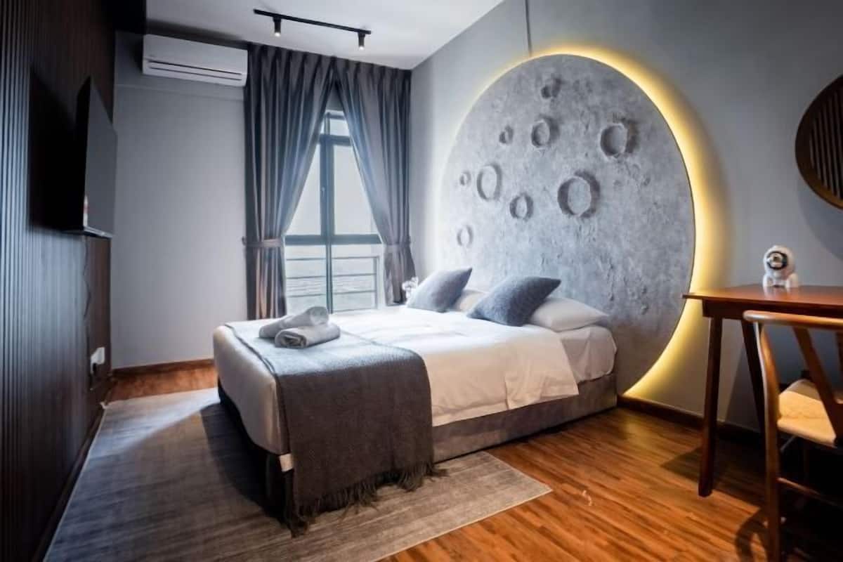 Une chambre moderne avec un lit, un élément décoratif rond sur le mur, une fenêtre et une table.