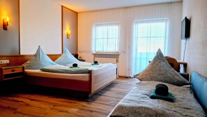Una habitación de hotel con cama, sofá, escritorio y televisor.