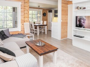 Un salon moderne avec un canapé, une table basse en bois et un téléviseur.