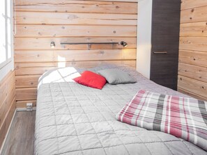 Une pièce comprenant un lit, une tête de lit, une table de chevet et une porte.